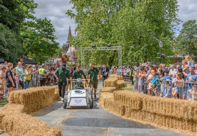 A hand-built soapbox kart races down the track at Dunstable's Soapbox Derby in Priory Gardens.