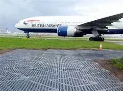 British Airways jet on airport tarmac, next to grass with a textured TuffTrak mat in the foreground.